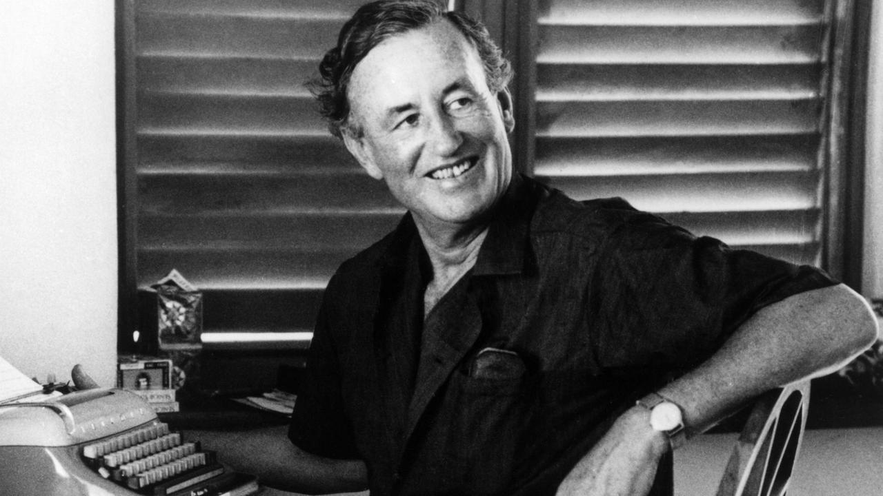 Der britische Autor Ian Fleming sitzt lächelnd an seiner Schreibmaschine Der britische Autor Ian Fleming sitzt lächelnd an seiner Schreibmaschine