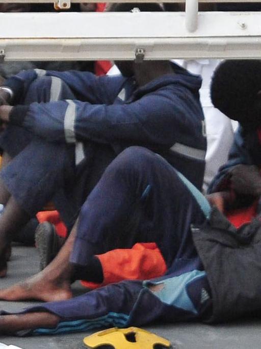 Auf dem Deck eines Schiffs der italienischen Küstenwache liegen gerettete Flüchtlinge.