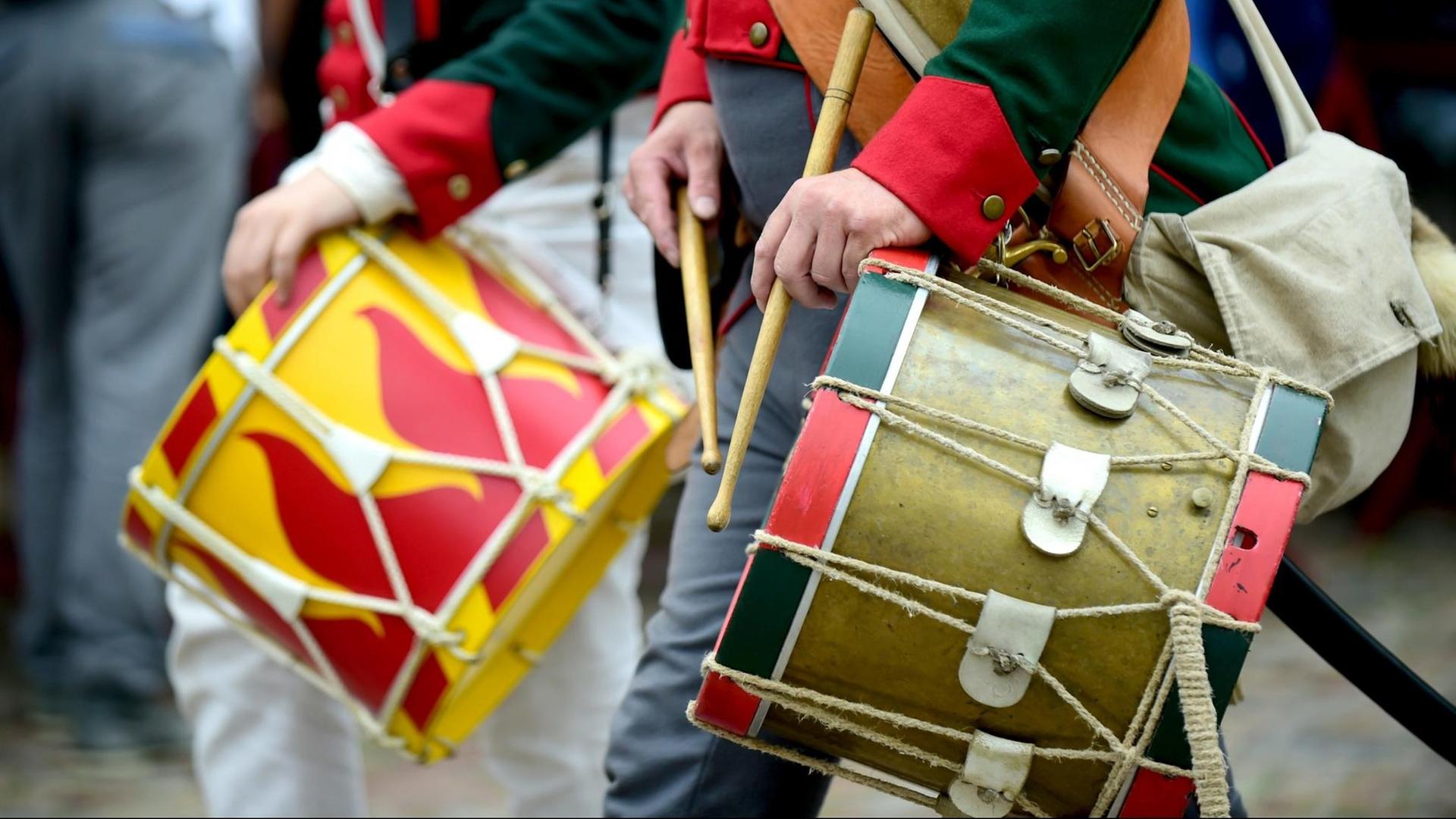 Teilnehmer in historischen Uniformen marschieren mit Trommeln über einen Weg, während in der historischen Festungsanlage die Schlacht um Bourtange im Jahr 1814 nachgestellt wird. Teilnehmer in historischen Uniformen marschieren mit Trommeln über einen Weg, während in der historischen Festungsanlage die Schlacht um Bourtange im Jahr 1814 nachgestellt wird.