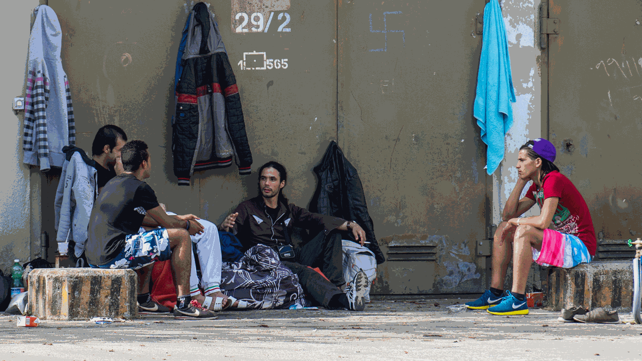Mehrere Flüchtlinge sitzen am 10.10.2014 in München (Bayern) auf dem Gelände der Bayernkaserne neben ihren Koffern auf dem Asphalt. Am Abend zuvor haben rund 150 Flüchtlinge für eine bessere Unterbringung demonstriert. Mehrere Flüchtlinge sitzen am 10.10.2014 in München (Bayern) auf dem Gelände der Bayernkaserne neben ihren Koffern auf dem Asphalt. Am Abend zuvor haben rund 150 Flüchtlinge für eine bessere Unterbringung demonstriert.