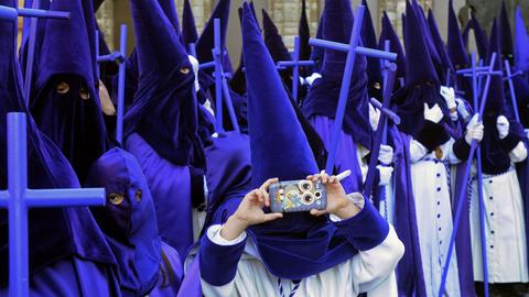 Ein Teilnehmer der traditionellen Oster-Prozession in Leon in Spanien macht am 5.4.2015 ein Foto mit seinem Smartphone.