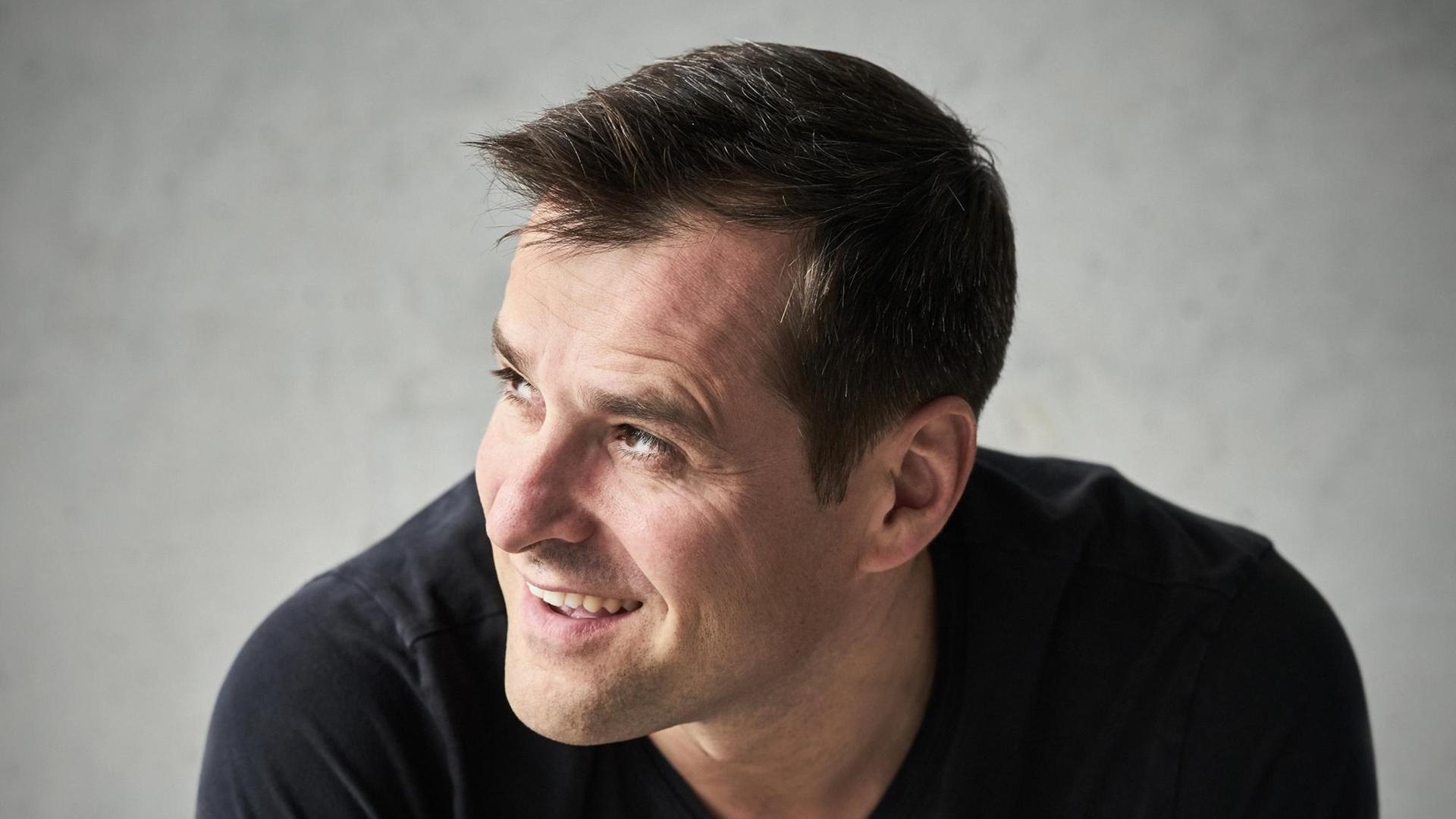 Der Baritonsänger Holger Falk blickt lachend zur Seite Der Baritonsänger Holger Falk blickt lachend zur Seite