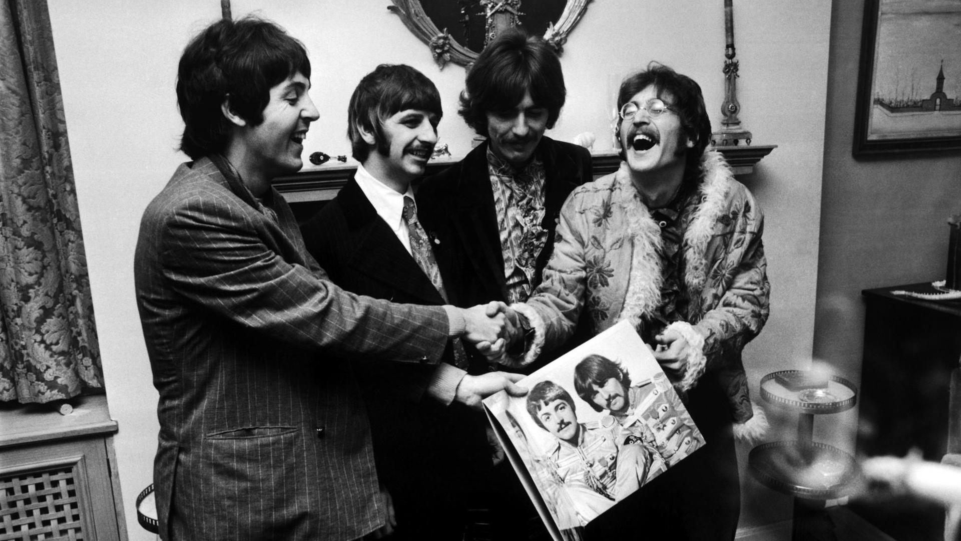 Die Beatles (von links nach rechts) George Harrison (1943 - 2001), Ringo Starr, John Lennon (1940 - 1980) und Paul McCartney halten die Hülle ihrer neuen LP "Sgt. Pepper's Lonely Hearts Club Band" am 19. Mai 1967. Die Beatles (von links nach rechts) George Harrison (1943 - 2001), Ringo Starr, John Lennon (1940 - 1980) und Paul McCartney halten die Hülle ihrer neuen LP "Sgt. Pepper's Lonely Hearts Club Band" am 19. Mai 1967.