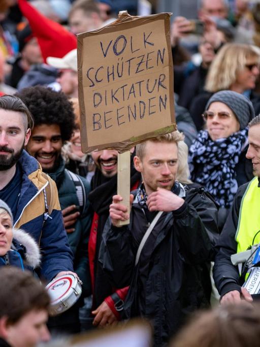 Demonstration gegen die Corona Auflagen. Teilnehmer auf einer Kundgebung auf dem Friedrichsplatz in Kassel. Sie stehen eng beieinander und tragen keine Masken. 20. März 2021.