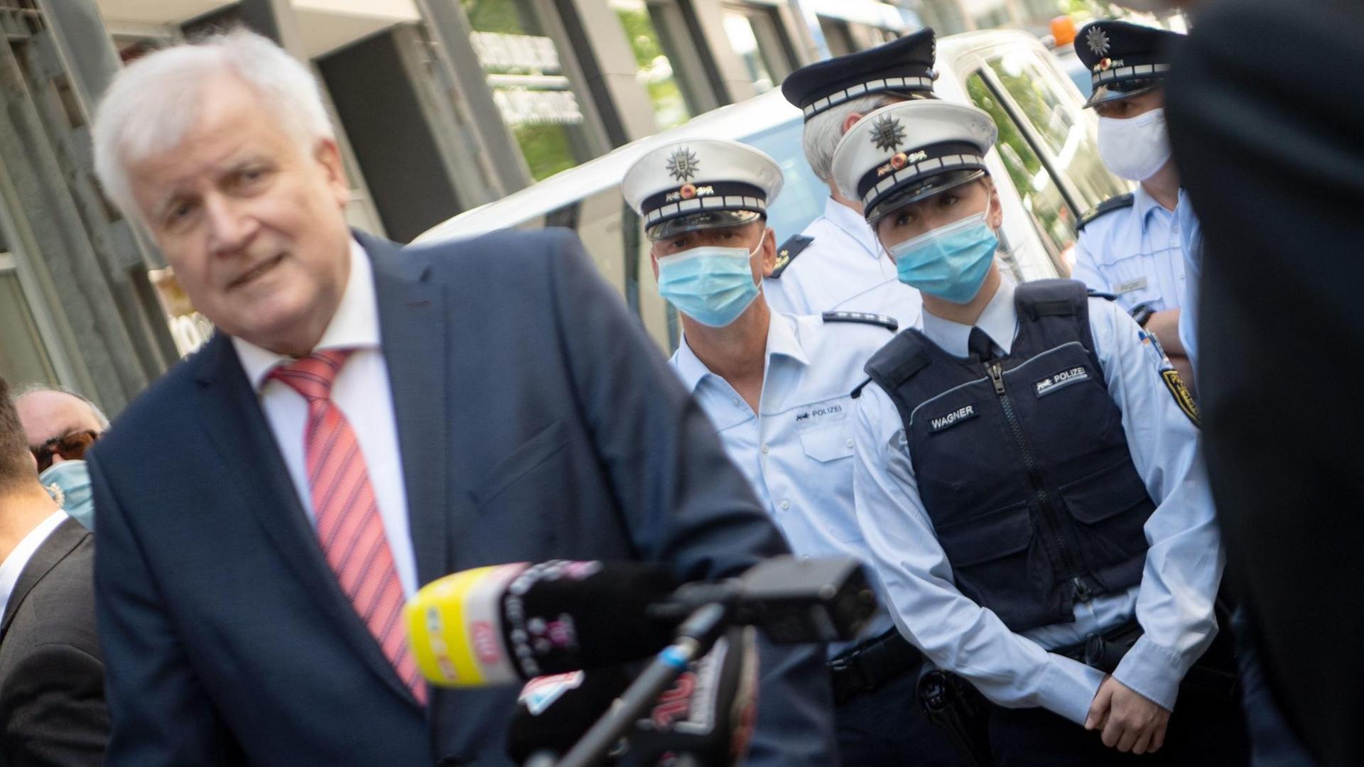 Bundesinnenminister Horst Seehofer steht in Stuttgart vor Polizisten, die einen Mundschutz tragen. Bundesinnenminister Horst Seehofer steht in Stuttgart vor Polizisten, die einen Mundschutz tragen.