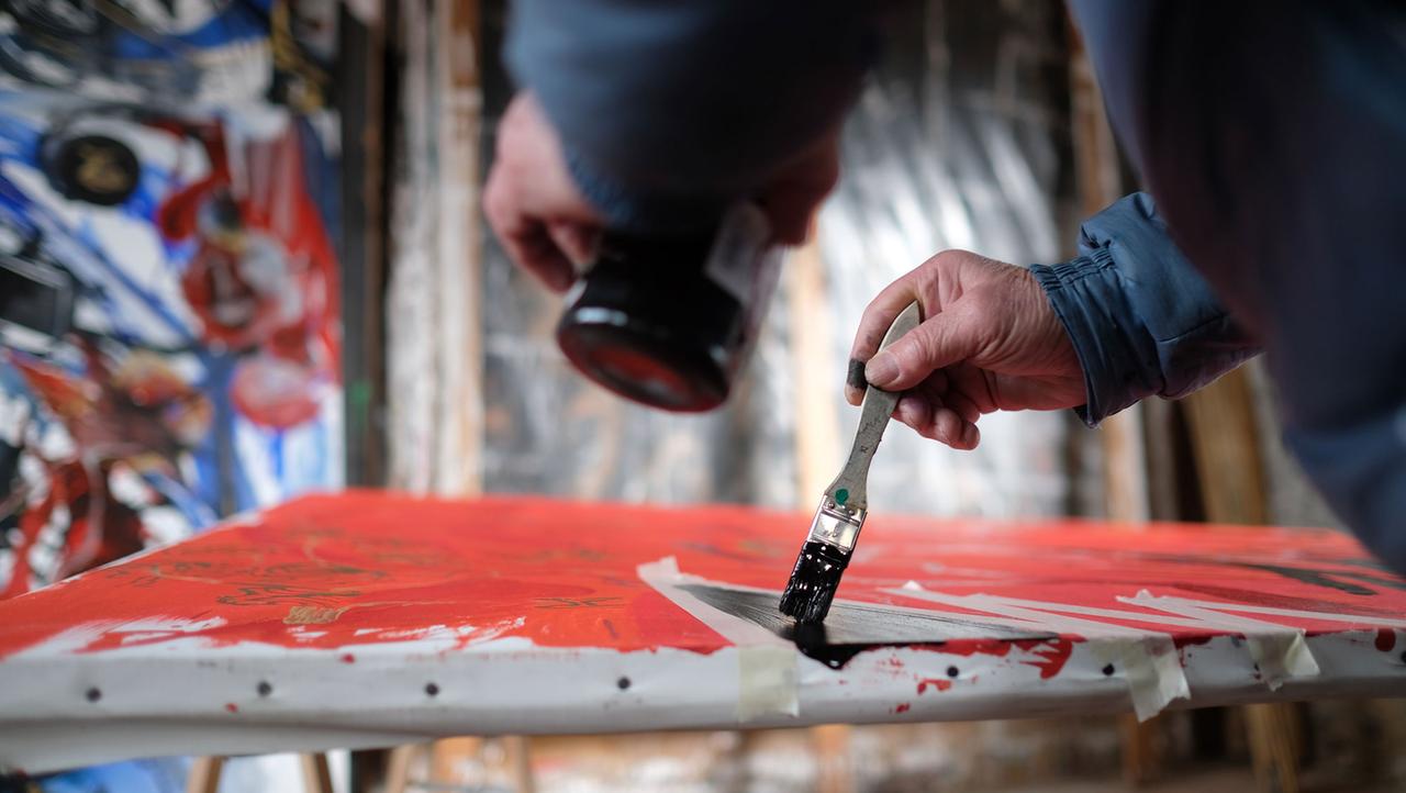 Der Künstler Valère Novarina trägt in seinem Atelier in der Normandie Farben auf ein Bild auf. Der Künstler Valère Novarina trägt in seinem Atelier in der Normandie Farben auf ein Bild auf.