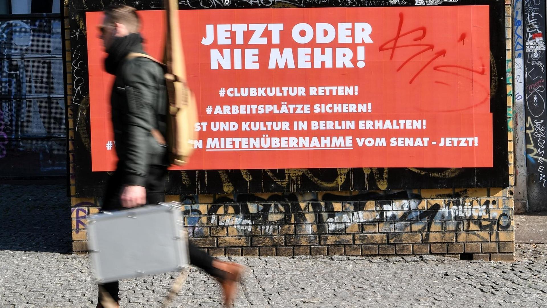 Ein Mann passiert ein Plakat mit der Aufschrift "Jetzt oder nie mehr! #Clubkultur retten!" Ein Mann passiert ein Plakat mit der Aufschrift "Jetzt oder nie mehr! #Clubkultur retten!"