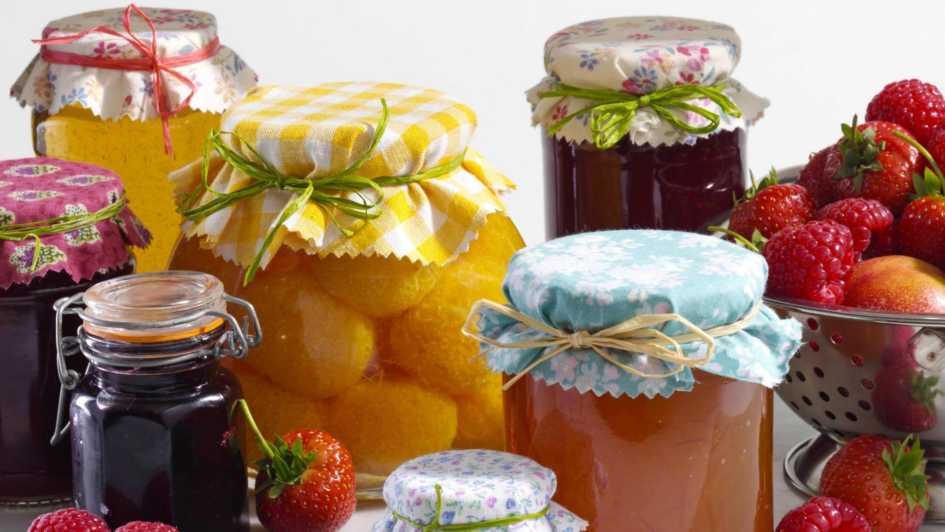 Gläser mit eingemachtem Obst stehen vor weißenm Hintergrund. Gläser mit eingemachtem Obst stehen vor weißenm Hintergrund.