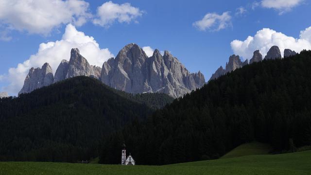 Clouds hang over the St. Johann chapel and the Dolomites mountains in St. Maddalena, St. Magdalena, in Val di Funes (Villnoess), in northern Italian province of South Tyrol, Italy, Friday, Aug. 20, 2021. (AP Photo/Matthias Schrader)