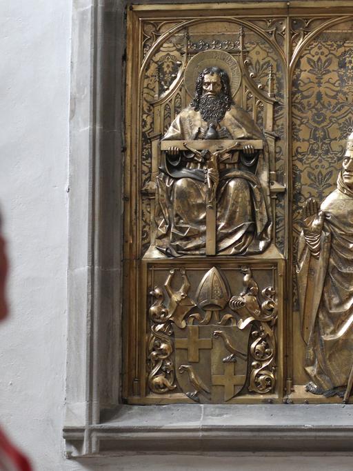 Eine Frau steht am 07.08.2014 im Dom von Merseburg (Sachsen-Anhalt) vor einem Epitaph aus dem 15. Jahrhundert mit der Abbildung des Thilo von Trotha. Der 500. Todestag des Kirchenfürsten ist Anlass für die Sonderausstellung, die vom 10.8. bis 2.11.2014 im Dom zu Merseburg und im Kulturhistorischen Museum Schloss Merseburg zu sehen ist.