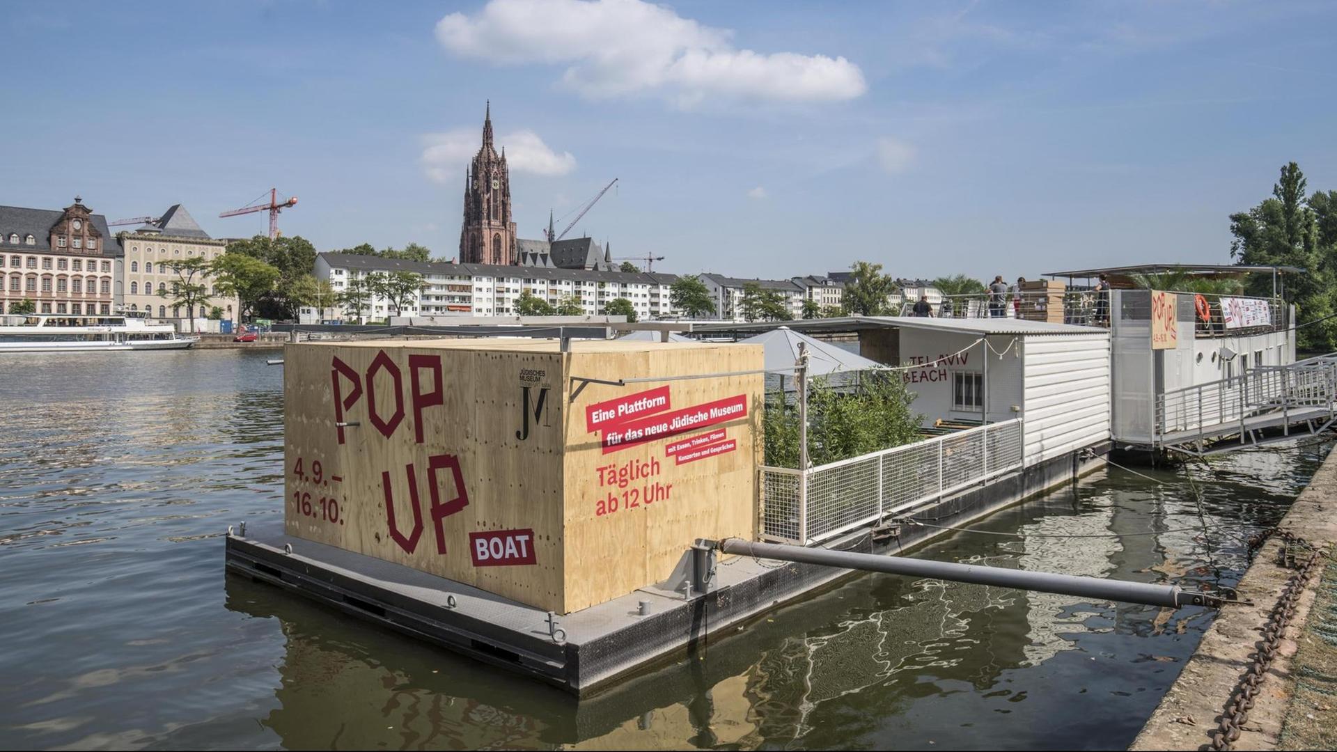 Ein Hausboot mit einem kastenförmigen Aufbau auf dem Main. Ein Hausboot mit einem kastenförmigen Aufbau auf dem Main.