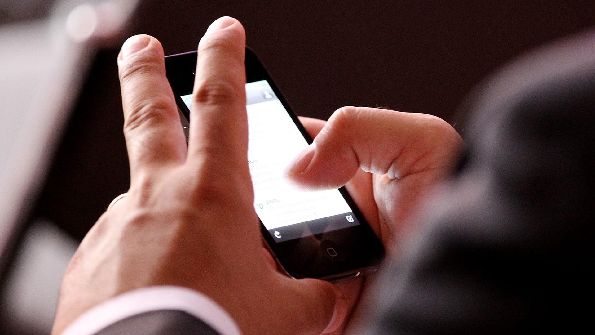 Mann im Anzug hat ein Smartphone in der Hand Mann im Anzug hat ein Smartphone in der Hand