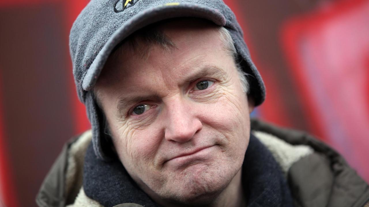 Der französische Künstler Thierry Noir gibt am 01.03.2013 an der East Side Gallery in Berlin vor der Baustelle ein Interview. Um Zugänge zu den Grundstücken an der Spree zu schaffen, wurde am Freitag damit begonnen Mauerstücke zu entfernen. Nachdem sich mehrere hundert Menschen eingefunden hatten, um gegen den Abriss zu protestieren, wurden die Arbeiten vorerst abgebrochen. Foto: Florian Schuh/dpa | Der französische Künstler Thierry Noir gibt am 01.03.2013 an der East Side Gallery in Berlin vor der Baustelle ein Interview. Um Zugänge zu den Grundstücken an der Spree zu schaffen, wurde am Freitag damit begonnen Mauerstücke zu entfernen. Nachdem sich mehrere hundert Menschen eingefunden hatten, um gegen den Abriss zu protestieren, wurden die Arbeiten vorerst abgebrochen. Foto: Florian Schuh/dpa |