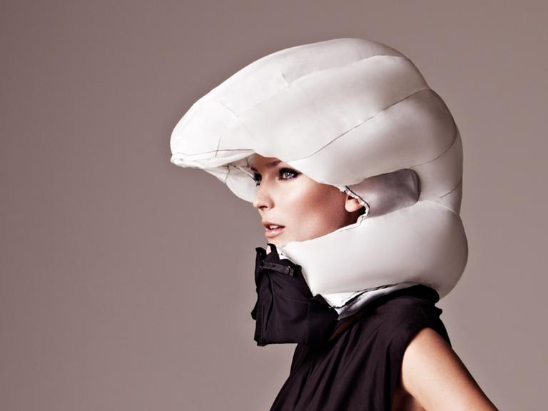 Eine Frau trägt einen Fahrrad-Airbag: Im Normalfall liegt er wie eine Art Schal um den Hals. Beim Sturz stülpt er sich blitzschnell um den Kopf.