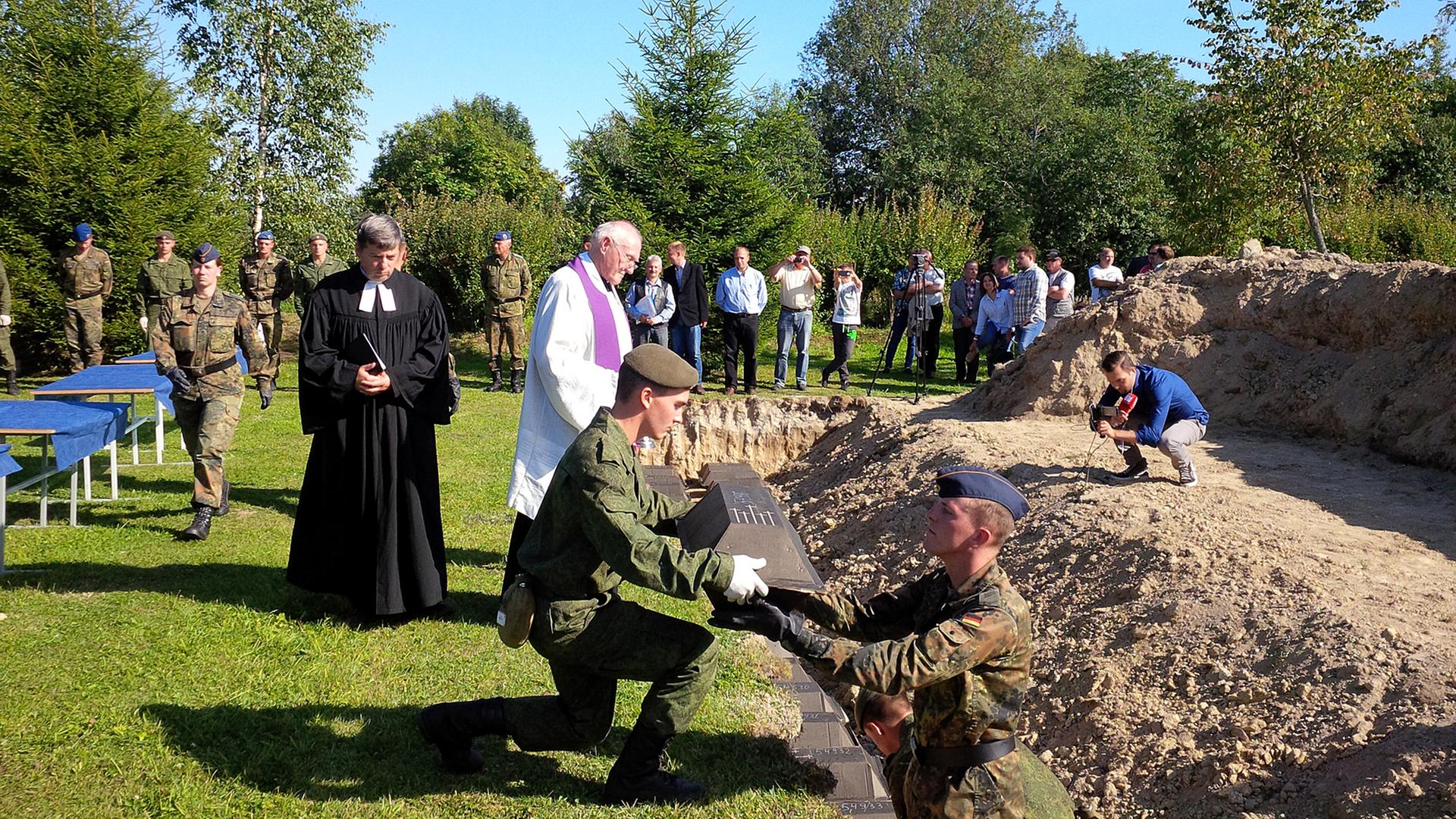 Friedhof Sologubowka bei Sankt Petersburg. Bestattung deutscher Wehrmachtssoldaten, deren sterbliche Überreste Bundeswehrsoldaten und russische Armeeangehörige auf dem ehemaligen Schlachtfeld exhumiert haben. Friedhof Sologubowka bei Sankt Petersburg. Bestattung deutscher Wehrmachtssoldaten, deren sterbliche Überreste Bundeswehrsoldaten und russische Armeeangehörige auf dem ehemaligen Schlachtfeld exhumiert haben.