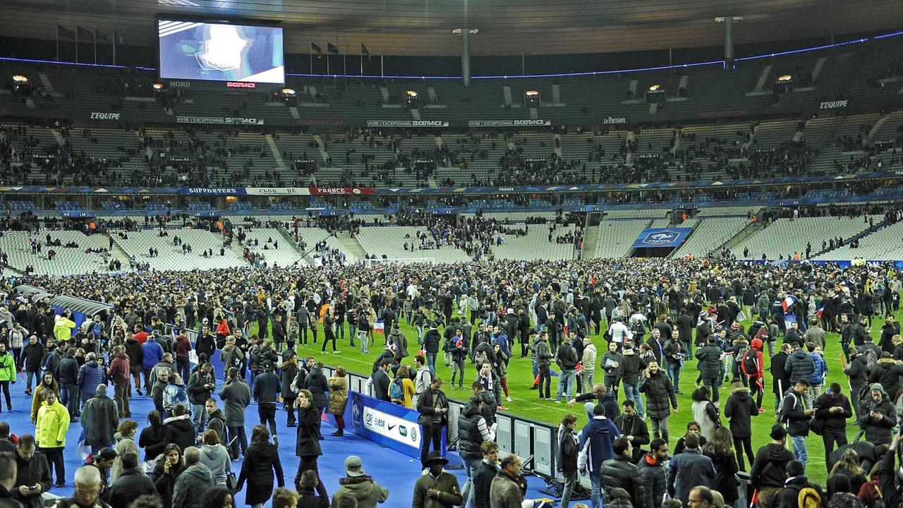 Hunderte Menschen auf dem Rasen des Stade de France, die Ränge sind größtenteils leer. Hunderte Menschen auf dem Rasen des Stade de France, die Ränge sind größtenteils leer.