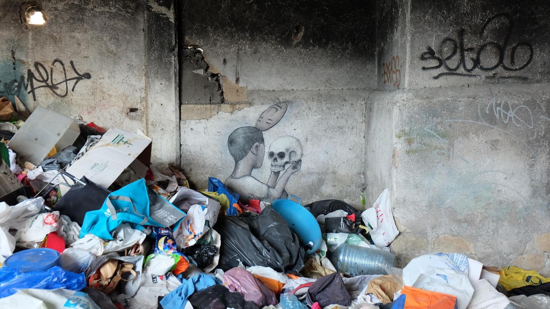 Ein Werk des französischen Street-Art-Künstlers Seth an einer Wand hinter Haufen von Müll auf dem Gelände einer besetzten früheren Seifenfabrik, dem Museo Abusivo Gestito dai Rom (MAGR) in Rom, zu sehen, aufgenommen im Juni 2019.