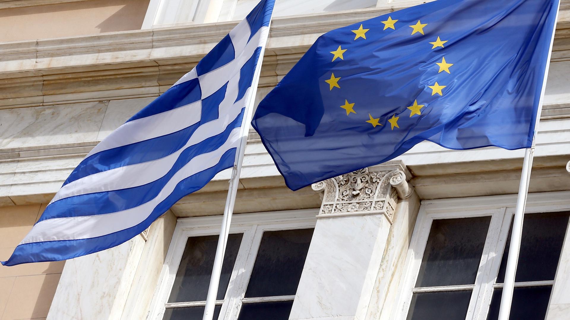 Die griechische und die europäische Flagge wehen am 06.03.2014 vor dem Parlamentsgebäude in Athen. Foto: Wolfgang Kumm/dpa Die griechische und die europäische Flagge wehen am 06.03.2014 vor dem Parlamentsgebäude in Athen. Foto: Wolfgang Kumm/dpa