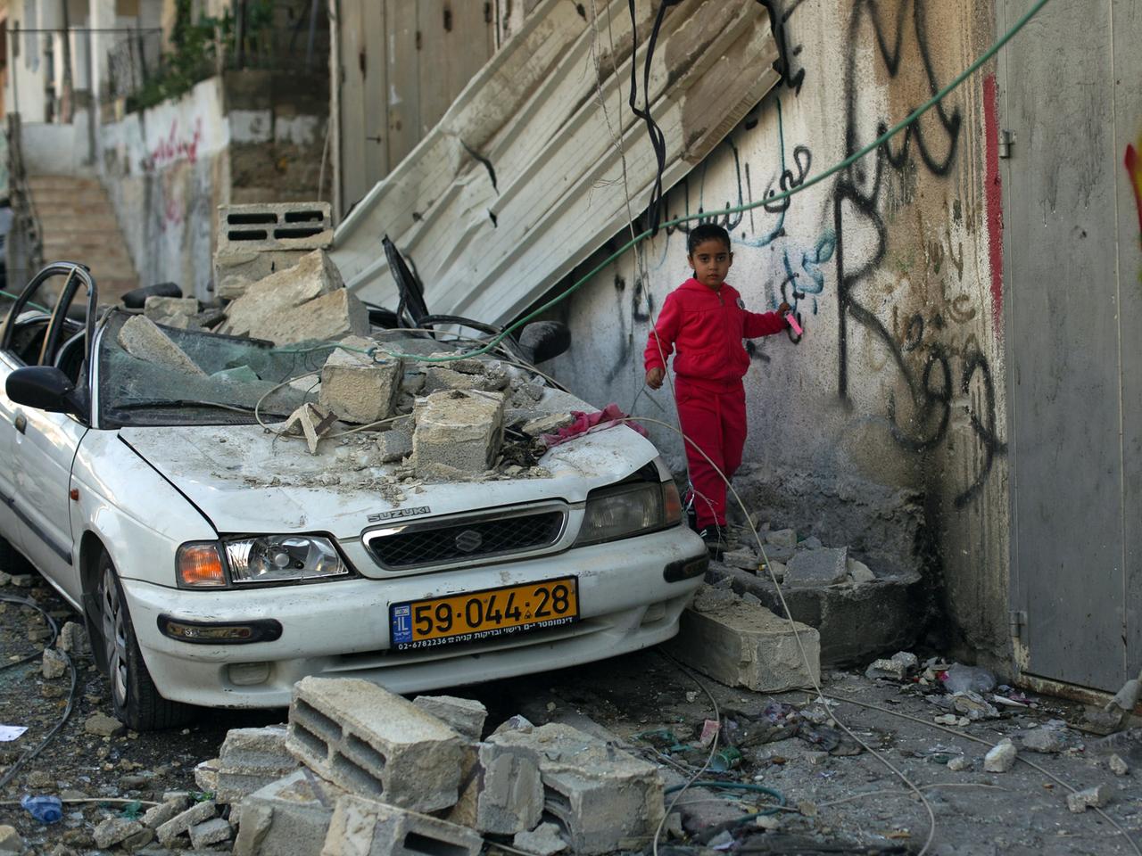 Ein Kind spielt zwischen den Trümmern des zerstörten Hauses eines palästinensischen Attentäters