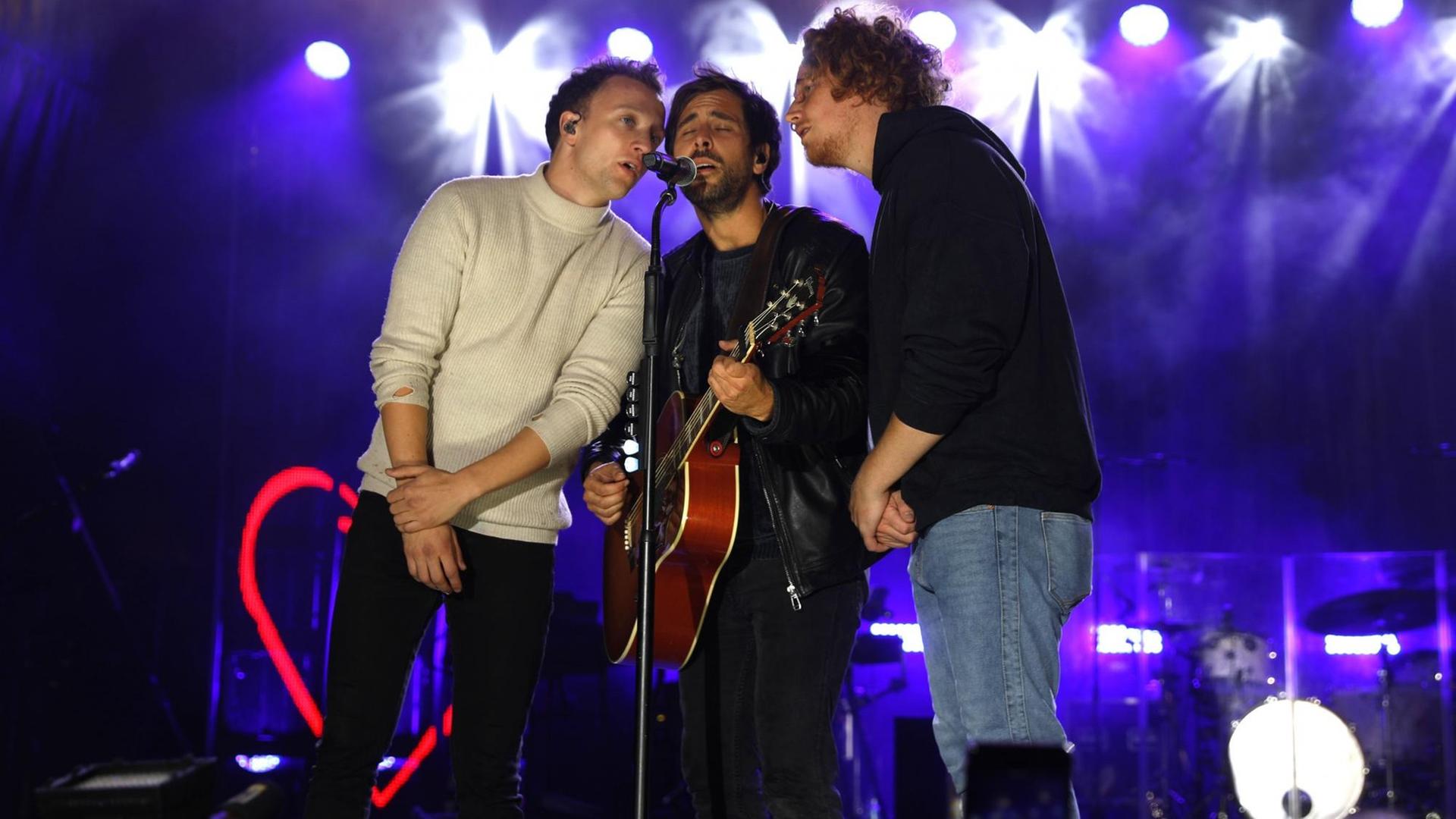 Joris, Max Giesinger und Michael Schulte singen zu dritt in ein Mikrofon. Joris, Max Giesinger und Michael Schulte singen zu dritt in ein Mikrofon.