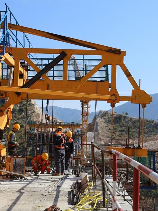 Bauarbeiter stehen auf einer großen Baustelle in Montenegro, wo China die erste Autobahnstrecke des Landes finanziert.