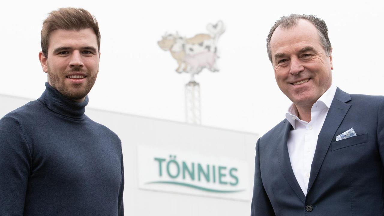 Der Miteigentümer der Unternehmensgruppe Tönnies Holding, Clemens Tönnies (r), und sein Sohn und Tönnies-Mitgesellschafter Maximilian Tönnies (l) stehen vor einem Firmengebäude mit dem Geschäftslogo.