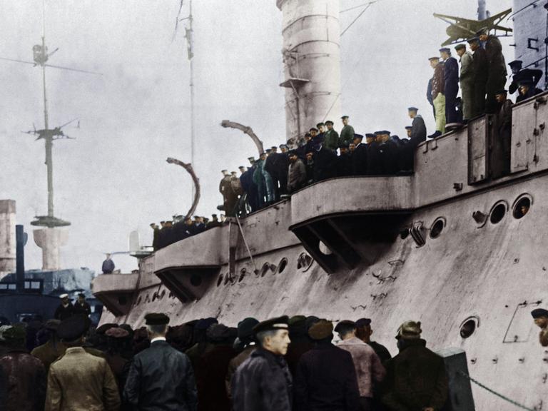 Zahlreiche Matrosen der Hochseeflotte stehen auf und vor einem der U-Boote, digital koloriertes Foto vom 5.11.1918