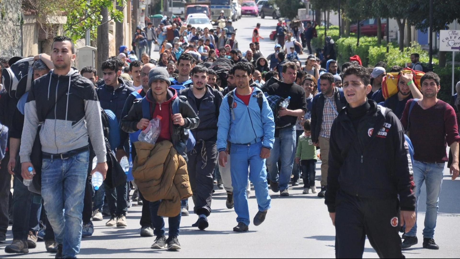 Flüchtlinge, zumeist Familien mit Kindern, laufen durch die Straßen auf der griechischen Insel Chios.