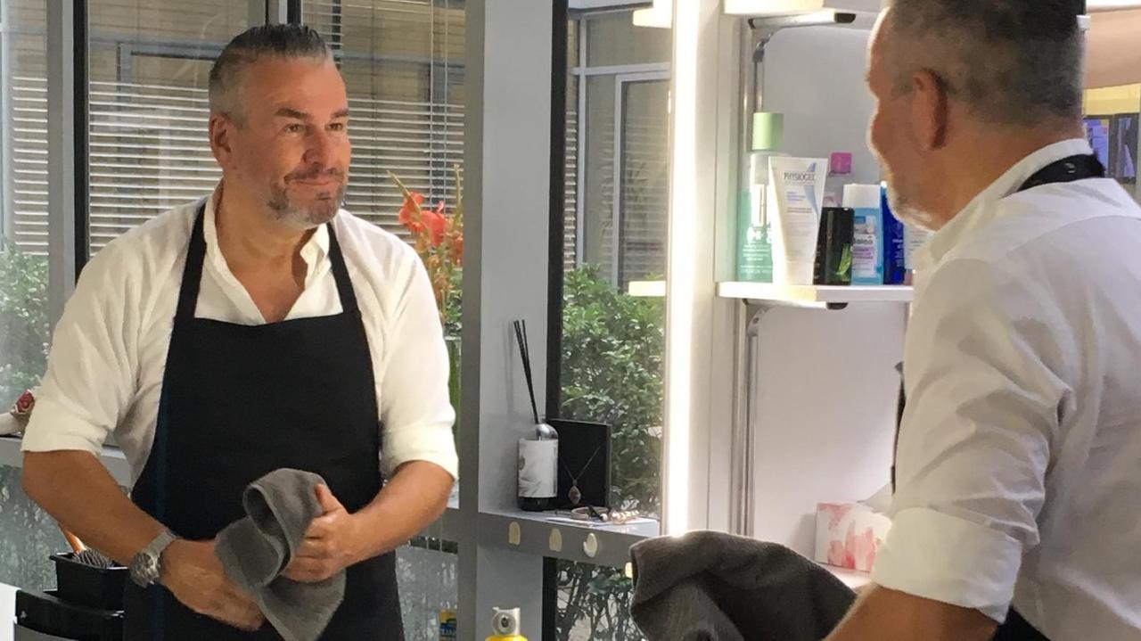 Der Verkäufer des Senders Channel21 guckt in einen Spiegel Der Verkäufer des Senders Channel21 guckt in einen Spiegel