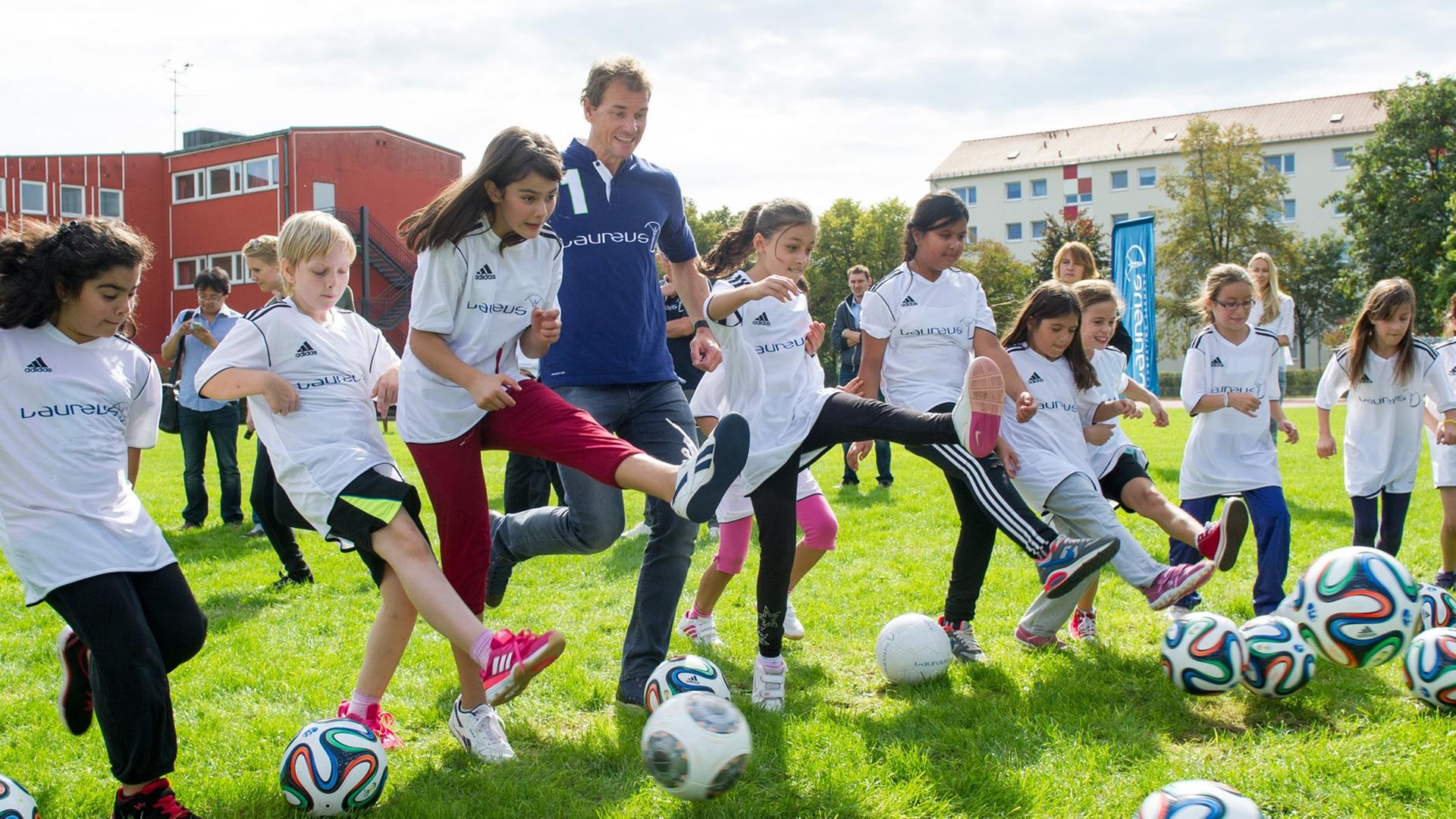 Der Laureus-Botschafter und frühere Torhüter Jens Lehmann kickt mit Schülerinnen vom Projekt "Kicking Girls" am 19.09.2014 in München (Bayern) auf dem Sportplatz der Grundschule an der Bad-Soden-Straße Fußbälle. Botschafter der Laureus-Stiftung besuchten Kinder und Trainer des Projekts "Kicking Girls", bei dem Mädchen mit Migrationshintergrund an ihrer Schule in Trainings-AGs angeleitet werden. Der Laureus-Botschafter und frühere Torhüter Jens Lehmann kickt mit Schülerinnen vom Projekt "Kicking Girls" am 19.09.2014 in München (Bayern) auf dem Sportplatz der Grundschule an der Bad-Soden-Straße Fußbälle. Botschafter der Laureus-Stiftung besuchten Kinder und Trainer des Projekts "Kicking Girls", bei dem Mädchen mit Migrationshintergrund an ihrer Schule in Trainings-AGs angeleitet werden.