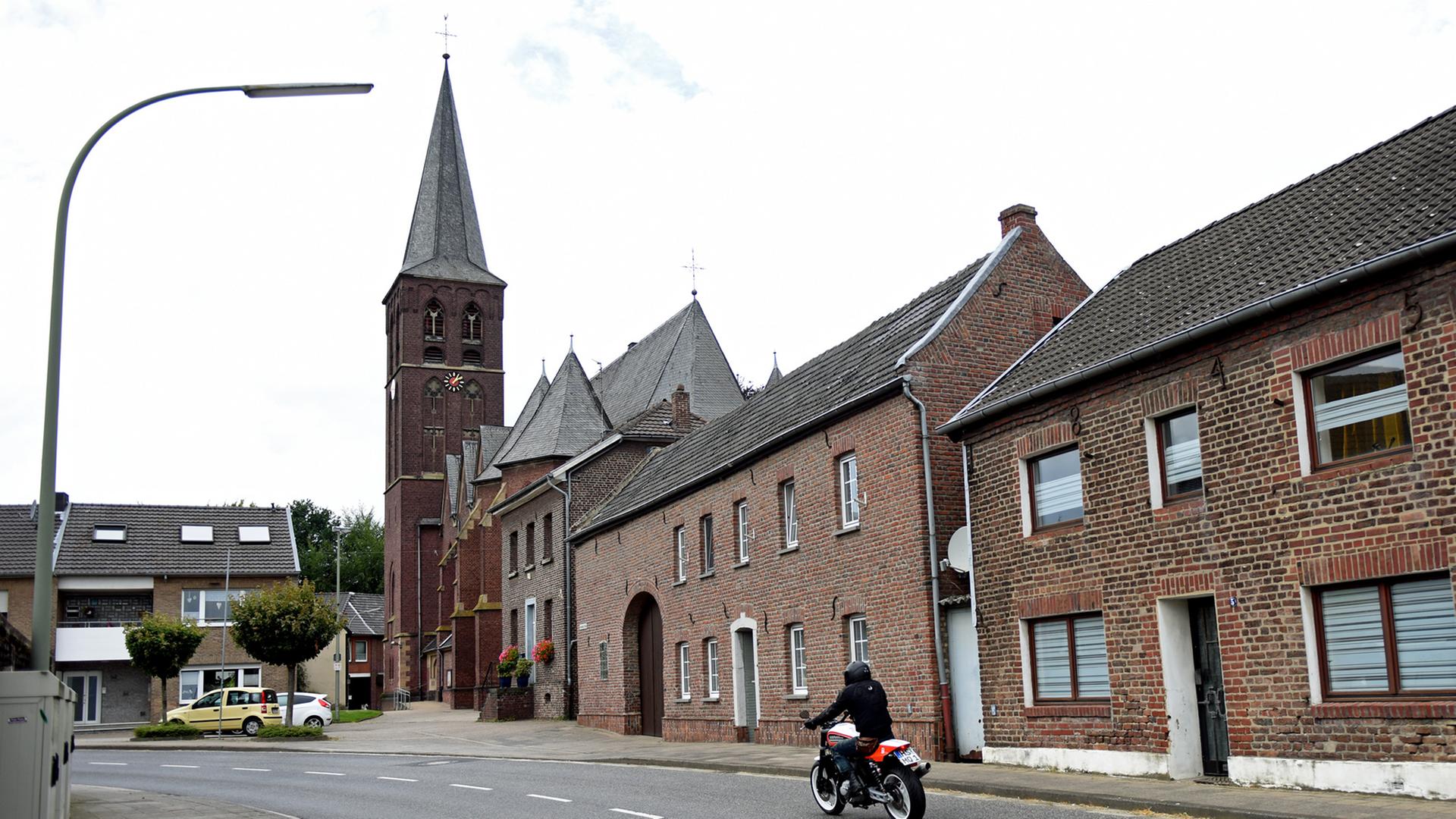 Ein Motorrad fährt durch das Dorf Keyenberg: Von den rund 800 Einwohnern haben sich viele schon umsiedeln lassen; Aufnahme vom August 2016 Ein Motorrad fährt durch das Dorf Keyenberg: Von den rund 800 Einwohnern haben sich viele schon umsiedeln lassen; Aufnahme vom August 2016