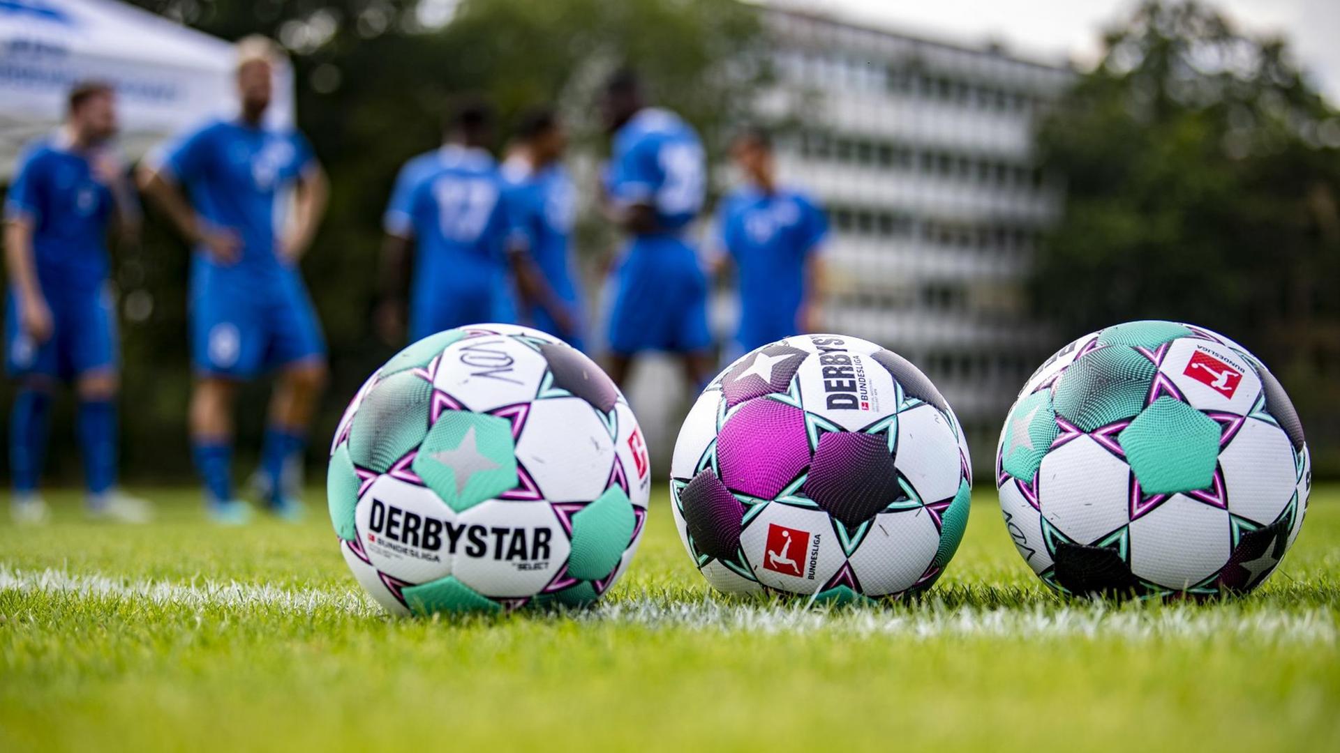 Neue Bälle liegen auf dem Rasen, im Hintergrund wärmen sich die Spieler des Proficamp der Vereinigung der Vertragsfußballspieler (VDV) auf. Neue Bälle liegen auf dem Rasen, im Hintergrund wärmen sich die Spieler des Proficamp der Vereinigung der Vertragsfußballspieler (VDV) auf.