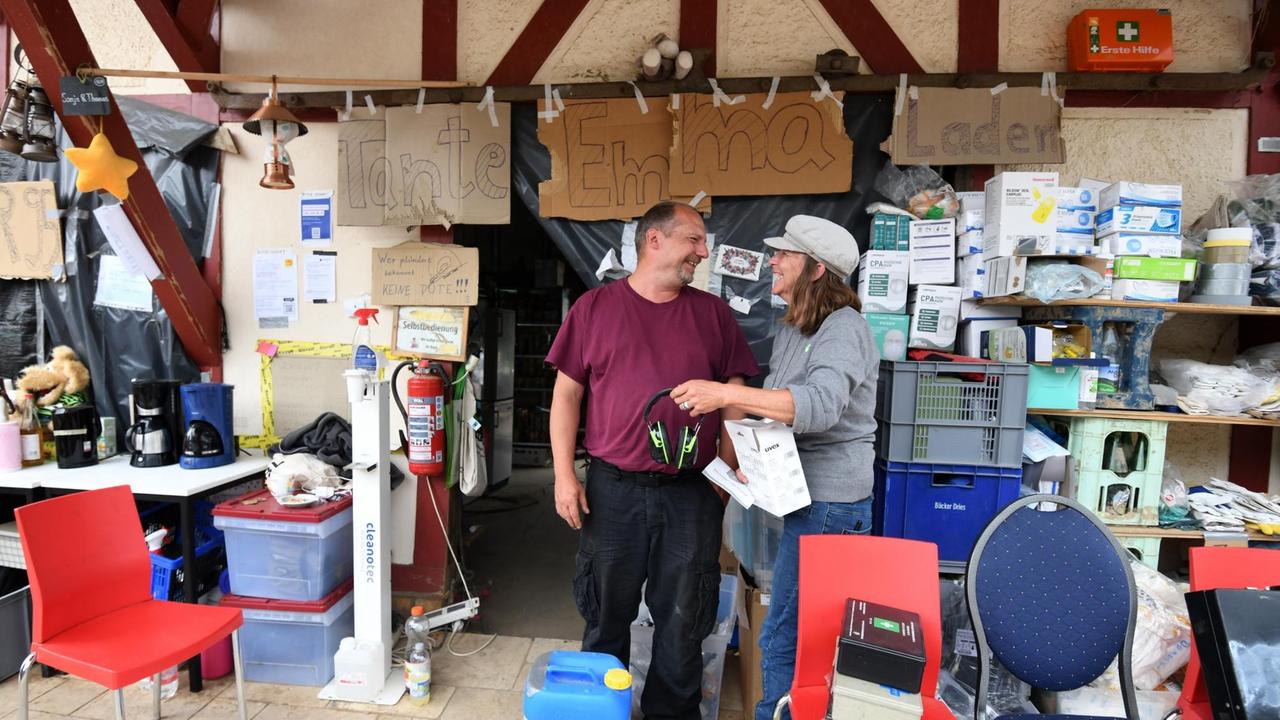 Freiwillige organisieren Hilfe in einem Laden für die Flutopfer in Dernau. Auf dem Schild über den Köpfen steht auf einem selbstgemalten Schild: Tante Emma Laden. 19. August 2021. Freiwillige organisieren Hilfe in einem Laden für die Flutopfer in Dernau. Auf dem Schild über den Köpfen steht auf einem selbstgemalten Schild: Tante Emma Laden. 19. August 2021.