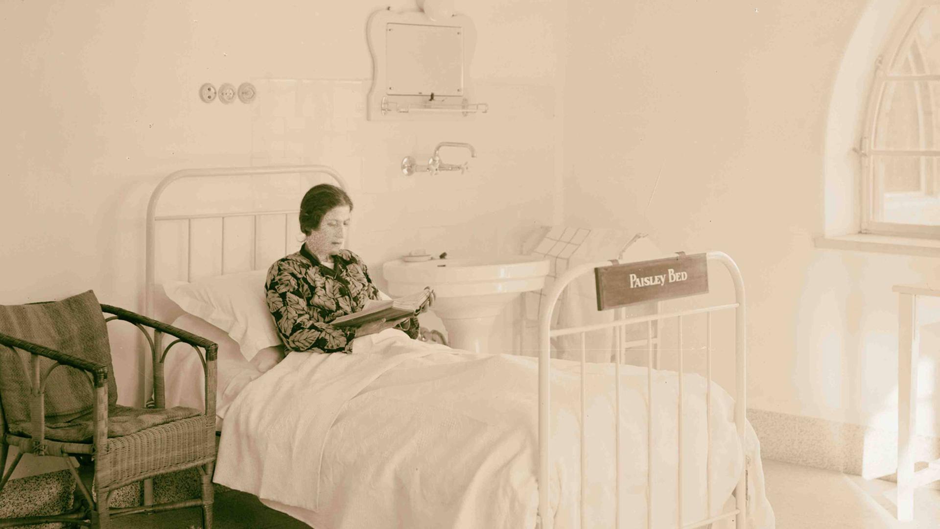 Eine Patientin liest auf dem Krankenbett Eine Patientin liest auf dem Krankenbett