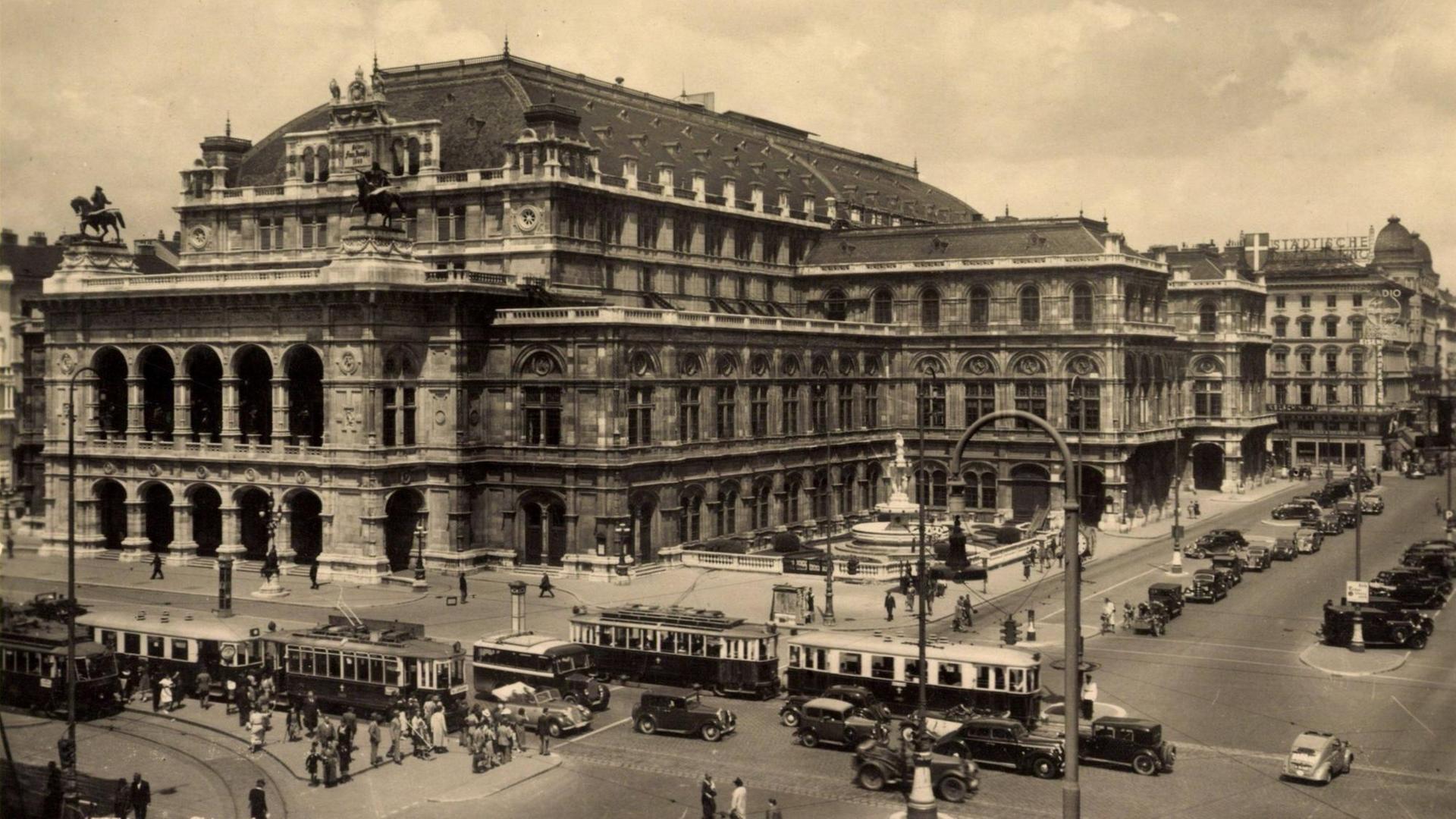 Die Staatsoper Wien in der Altstadt, Schwarz-Weiß-Aufnahme aus den 1930er Jahren, mit Straßenbahn- und Auto-Verkehr Die Staatsoper Wien in der Altstadt, Schwarz-Weiß-Aufnahme aus den 1930er Jahren, mit Straßenbahn- und Auto-Verkehr