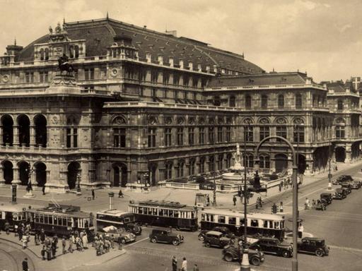 Die Staatsoper Wien in der Altstadt, Schwarz-Weiß-Aufnahme aus den 1930er Jahren, mit Straßenbahn- und Auto-Verkehr