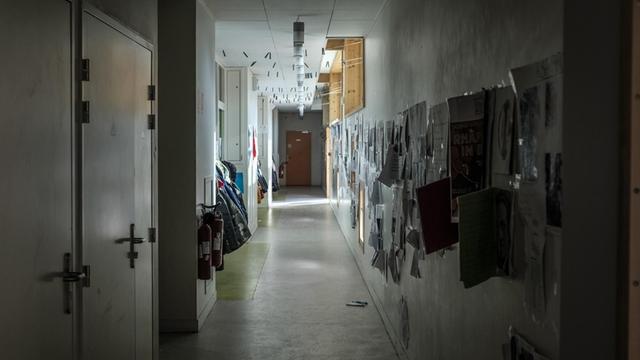 Blick in einen dunklen, leeren Schulkorridor