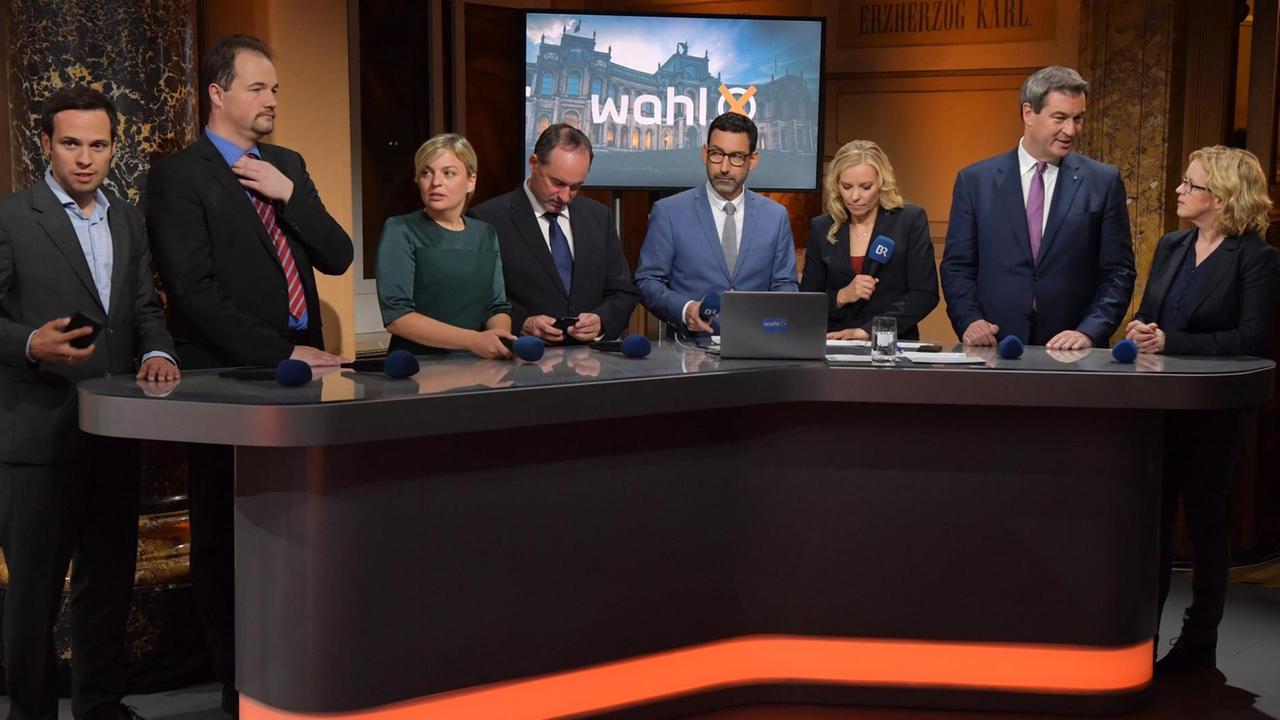 Markus Söder (2.v.r., CSU), Ministerpräsident von Bayern, spricht im ARD-Wahlstudio im Landtag neben SPD-Spitzenkandidatin Natascha Kohnen (r). Im Studio stehen die Spitzenkandidaten der Parteien (l-r) Martin Hagen (FDP), der AfD-Vorsitzende Martin Sichert, Katharina Schulze (Grüne), Hubert Aiwanger (Freie Wähler), Moderator Till Nassif sowie Moderatorin Birgit Kappel und warten auf den Beginn der Fernsehsendung. Markus Söder (2.v.r., CSU), Ministerpräsident von Bayern, spricht im ARD-Wahlstudio im Landtag neben SPD-Spitzenkandidatin Natascha Kohnen (r). Im Studio stehen die Spitzenkandidaten der Parteien (l-r) Martin Hagen (FDP), der AfD-Vorsitzende Martin Sichert, Katharina Schulze (Grüne), Hubert Aiwanger (Freie Wähler), Moderator Till Nassif sowie Moderatorin Birgit Kappel und warten auf den Beginn der Fernsehsendung.