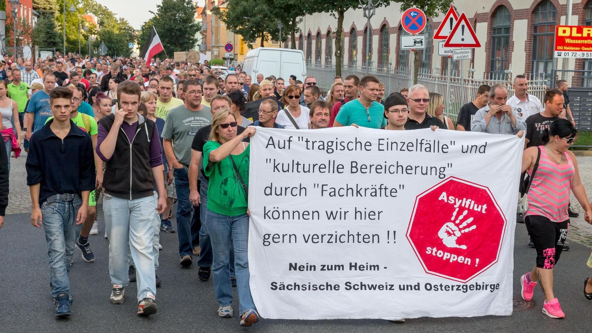Demonstranten tragen in Heidenau ein Plakat mit der Aufschrift: "Asylflut stoppen!" Demonstranten tragen in Heidenau ein Plakat mit der Aufschrift: "Asylflut stoppen!"