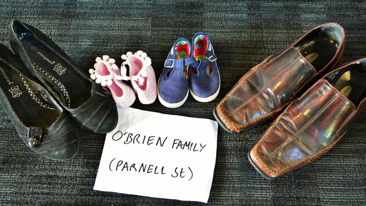 Ein Paar Damen- und Herrenschuhe sowie Schuhe von zwei Kindern mit einem Zettel auf dem O'Brien Family und Parnett Street zu lesen ist. Ein Paar Damen- und Herrenschuhe sowie Schuhe von zwei Kindern mit einem Zettel auf dem O'Brien Family und Parnett Street zu lesen ist.