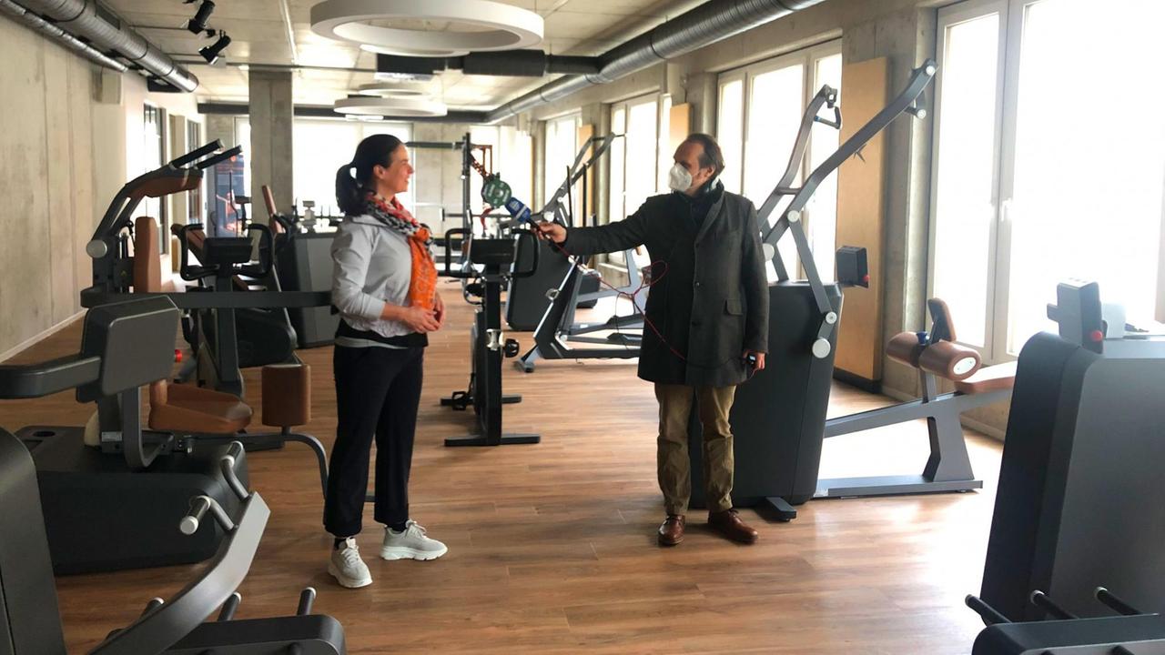 Die ehemalige Eiskunstläuferin Katarina Witt steht in ihrem Fitnessstudio "Kurvenstar" in Potsdam, der Journalist Christoph Richter streckt ihr ein Mikrofon entgegen. Die ehemalige Eiskunstläuferin Katarina Witt steht in ihrem Fitnessstudio "Kurvenstar" in Potsdam, der Journalist Christoph Richter streckt ihr ein Mikrofon entgegen.
