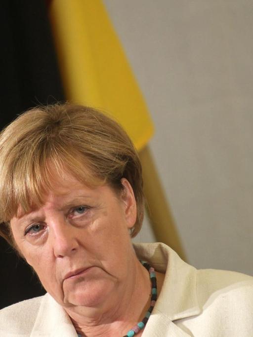 Bundeskanzlerin Angela Merkel schaut bei einer Pressekonferenz in Estland kritisch