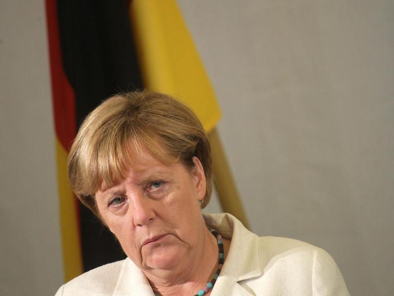 Bundeskanzlerin Angela Merkel schaut bei einer Pressekonferenz in Estland kritisch
