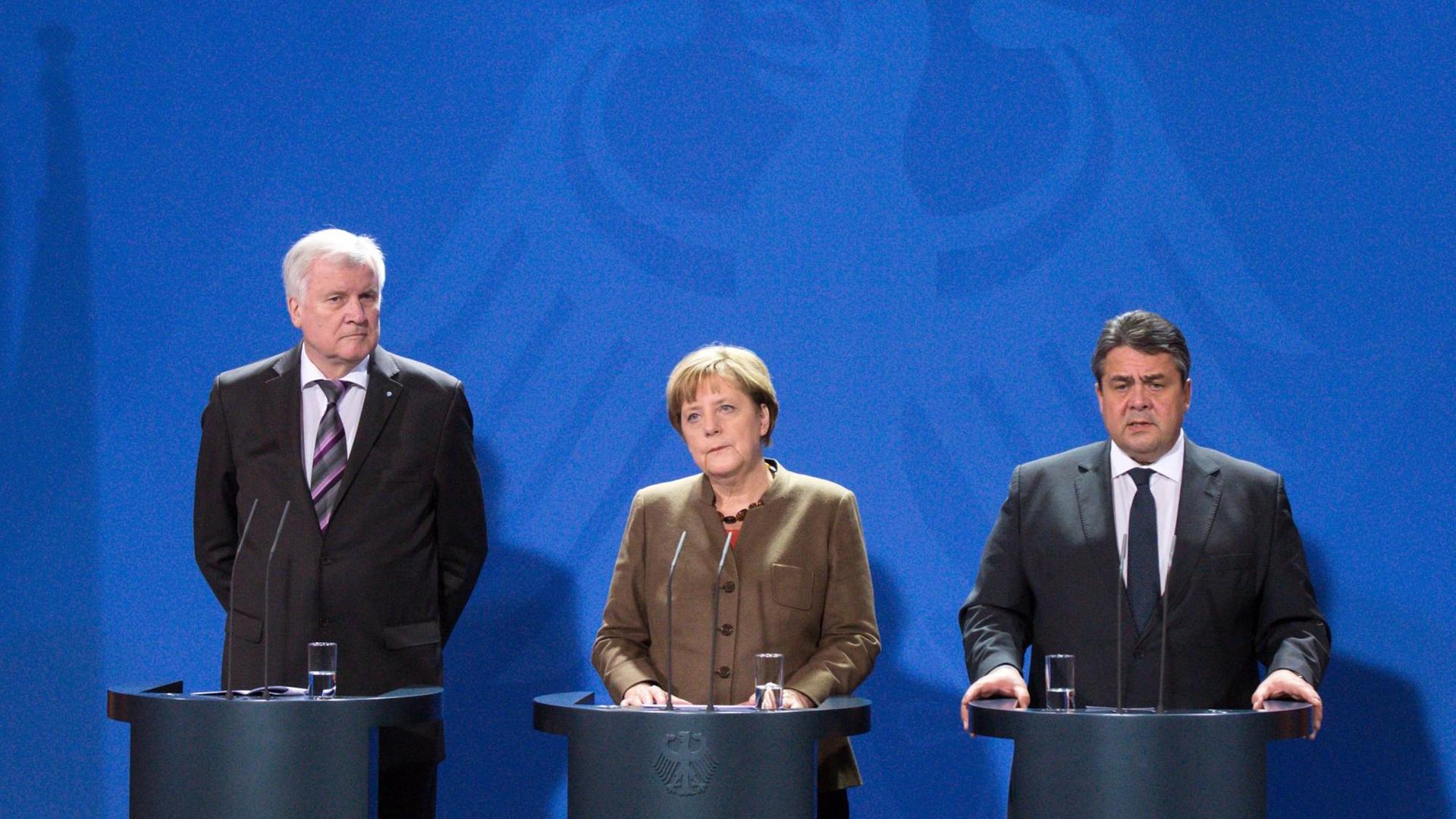Horst Seehofer, Angela Merkel und Sigmar Gabriel stehen im Kanzleramt vor einer blauen Wand mit dem Bundesadler.