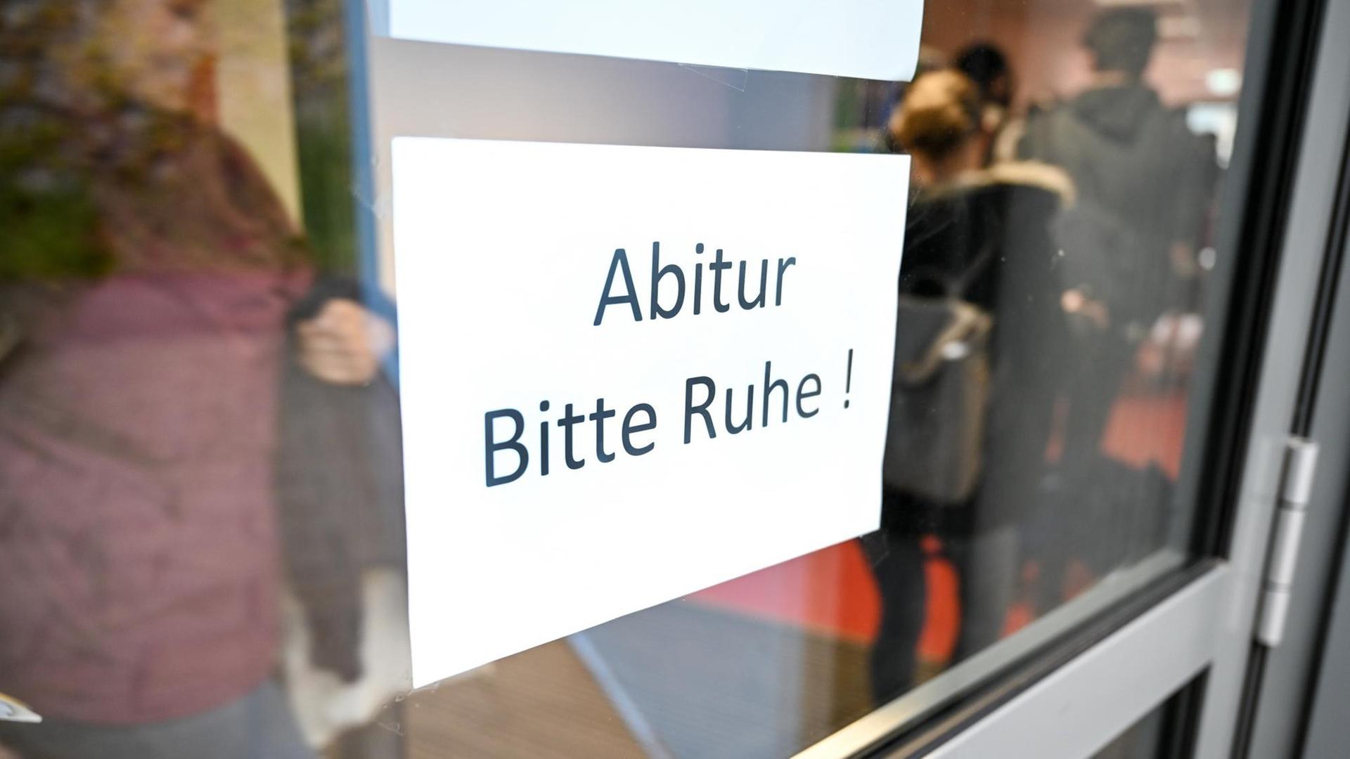 Abiturienten gehen in eime Gymnasium kurz vor Beginn des Abiturs im Fach Deutsch zu ihrem Prüfungsraum an einem Schild vorbei, auf dem "Abitur Bitte Ruhe!" steht. Abiturienten gehen in eime Gymnasium kurz vor Beginn des Abiturs im Fach Deutsch zu ihrem Prüfungsraum an einem Schild vorbei, auf dem "Abitur Bitte Ruhe!" steht.