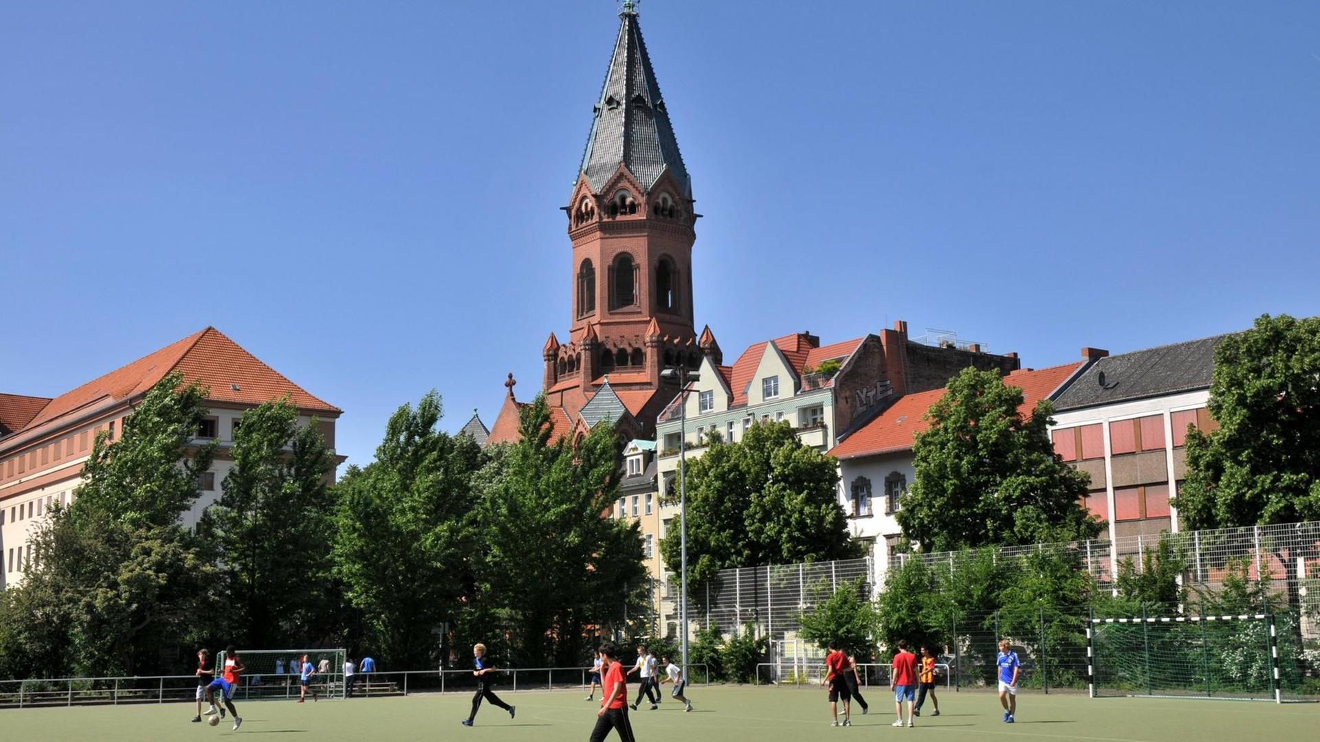 Sportplatz an der Gneisenaustraße in Berlin Kreuzberg, hinten die Passionskirche am Marheinekeplatz. Sportplatz an der Gneisenaustraße in Berlin Kreuzberg, hinten die Passionskirche am Marheinekeplatz.