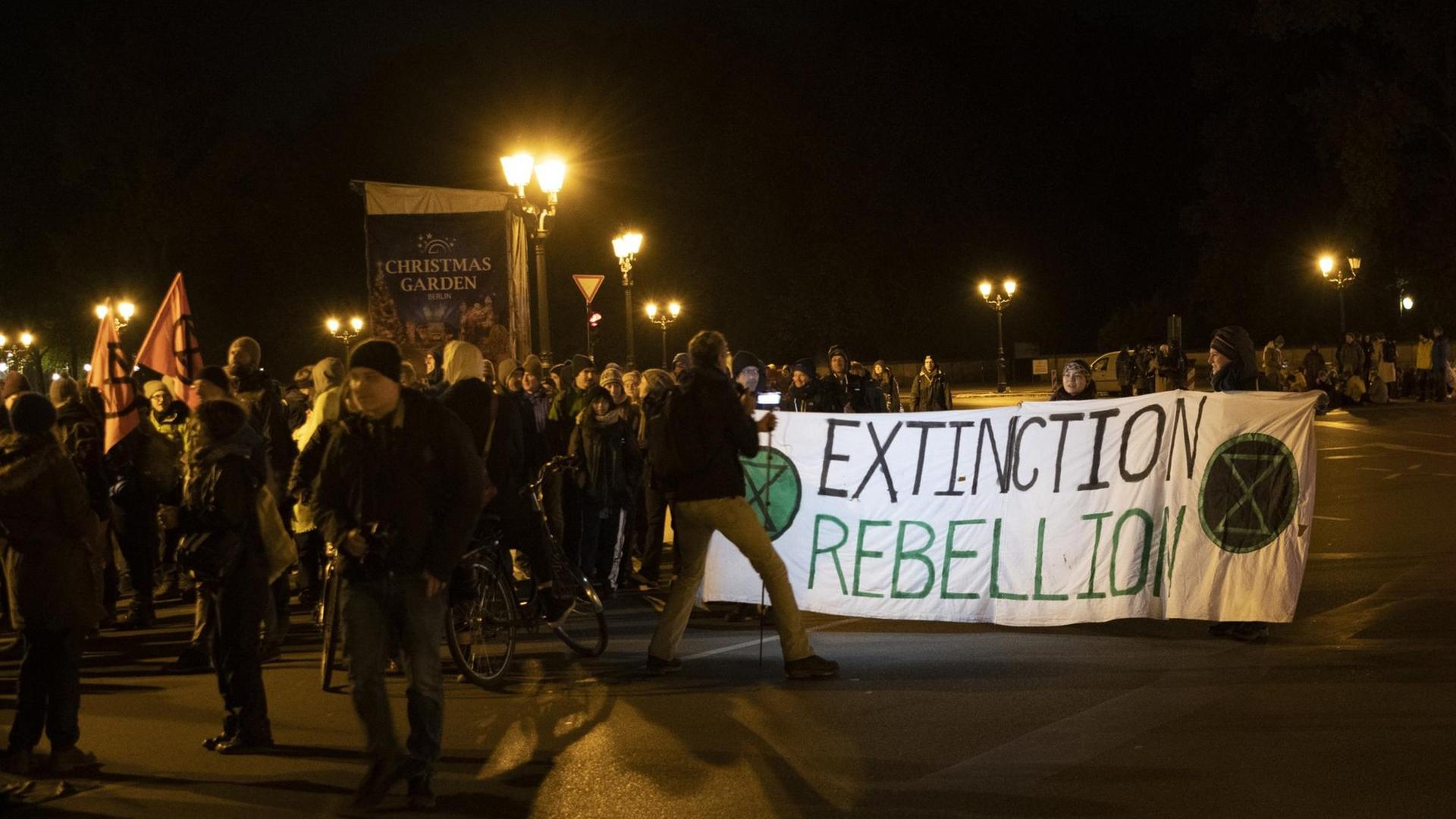 Aktivisten der Umweltschutzbewegung Extinction Rebellion blockieren die Zufahrten am Großen Stern an der Siegessäule in Berlin.
