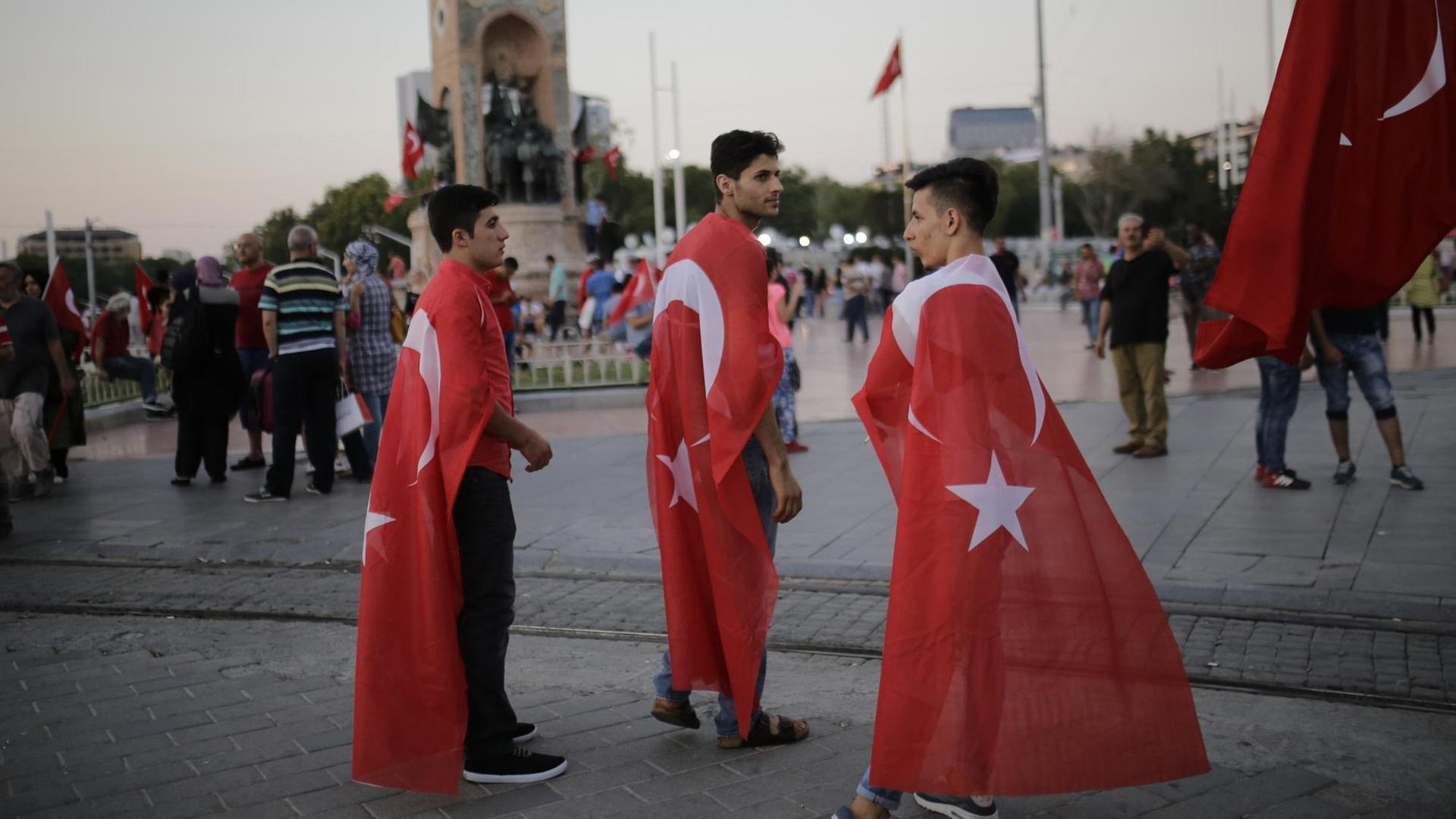 Junge Männer mit Türkeiflagge stehen einen Tag nach dem gescheiterten Militärputsch auf dem Taksim-Platz in Istanbul.