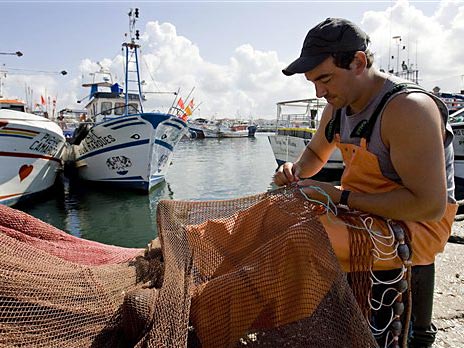 Ein portugiesischer Fischer repariert seine Netze im Hafen von Povoa de Varzim Ein portugiesischer Fischer repariert seine Netze im Hafen von Povoa de Varzim