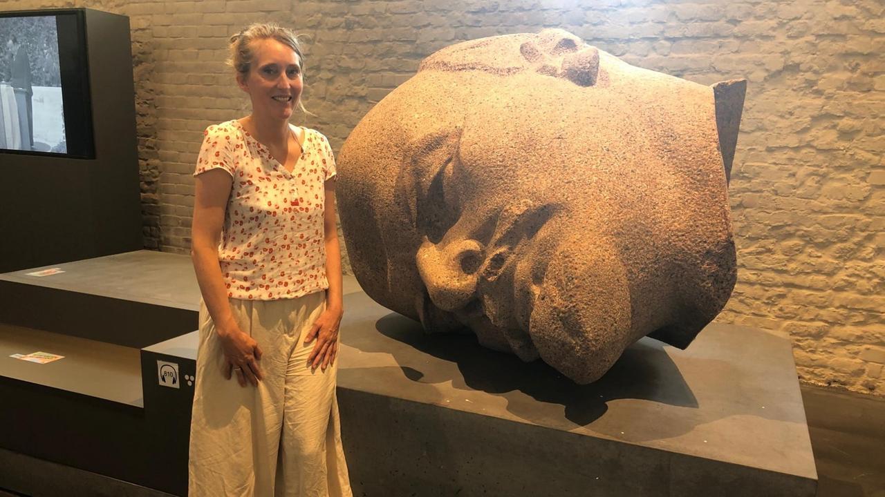 Museumsleiterin Urte Evert steht neben dem liegenden steinernen Lenin-Kopf. Museumsleiterin Urte Evert steht neben dem liegenden steinernen Lenin-Kopf.